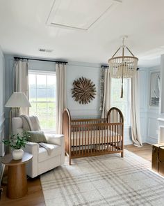 a baby's room with a crib, rocking chair and large window in it