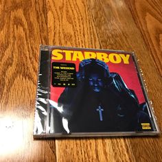 the cd cover for starboy is sitting on a wooden table