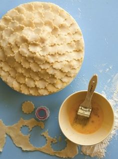 a blue table topped with lots of food and a bowl filled with batter next to a paintbrush