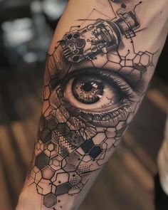 a tattoo with an eye and some sort of structure on the arm that is made up of hexagonal cubes