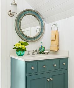 a bathroom with a sink, mirror and blue cabinet