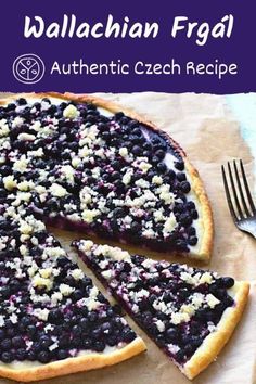 a blueberry cheesecake is cut into slices with a fork and knife on the side