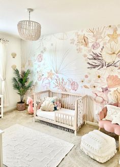 a baby's room with floral wallpaper and pink furniture