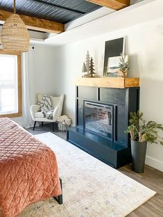 a bed room with a neatly made bed and a fire place in the middle of it