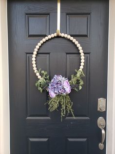 a black door with a wreath and flowers on it