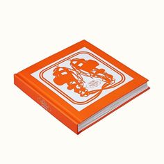 an orange and white book with the cover pulled back to reveal a drawing of two football helmets