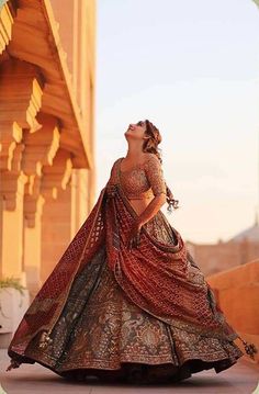 a woman in a long dress is standing outside