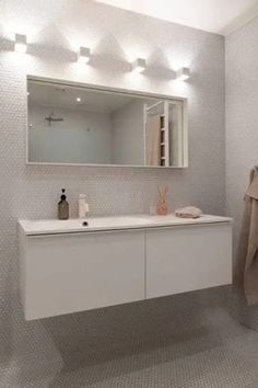 White hexagon tile on the walls and floors of this bathroom for an immersive effect