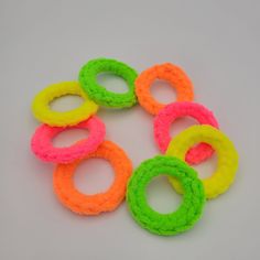 six neon colored rings on a white surface