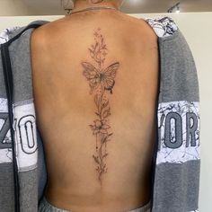 a woman with a butterfly tattoo on her back