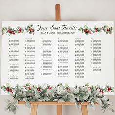 an easel with a seating chart on it and holly wreaths around the top