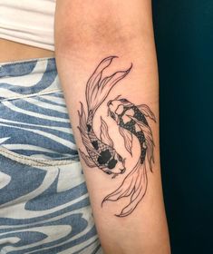 a woman's arm with a koi fish tattoo on it