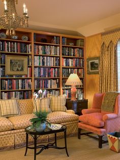 a living room filled with lots of furniture and bookshelves covered in bookcases