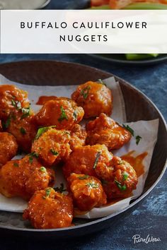 a plate full of meatballs covered in sauce and garnished with parsley