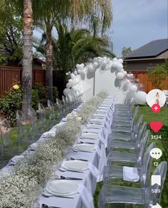 a long table set up with white plates and balloons