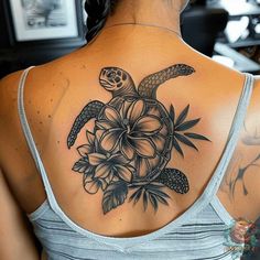 a woman with a turtle and flowers tattoo on her back