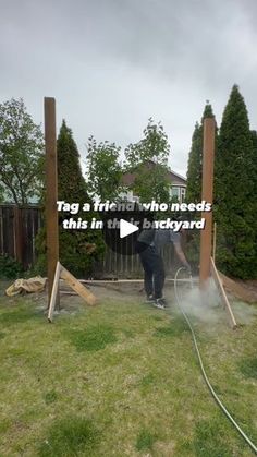 a man is using a hose to clean the yard