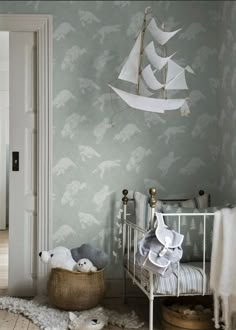 a baby's room with a sailboat wallpaper