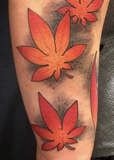 an orange and red flower tattoo on the leg