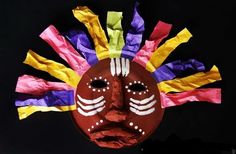 a mask made out of colored tissue paper with the face painted red, yellow and purple