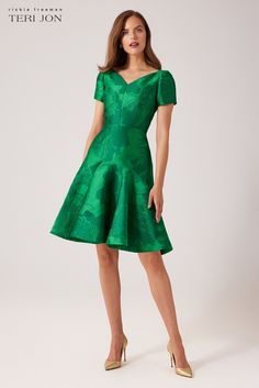 Make a bright statement in our mikado flounce skirt dress, designed to make you feel extraordinary. The v-neckline, short sleeves, and knee length cut strikes a balance between formal and casual, allowing you to dress it up or down as per your preference. The emerald green hue will make you the center of attention wherever you go, and the modern design is both comfortable and versatile, making it suitable for a wide range of occasions. Whether you’re headed to a cocktail party, garden party, or Elegant Green V-neck Short Sleeve Dress, Green Fitted V-neck Dress With Short Sleeves, Short Sleeve Midi Dress For Spring Gala, Spring Party Short Sleeve V-neck Dress, Modern Formal Mini Dress With Short Sleeves, Gala Dress With Fitted Bodice And Short Sleeves, Formal Green Fitted V-neck Dress, Green Fit And Flare V-neck Dress, Green V-neck Fit And Flare Dress