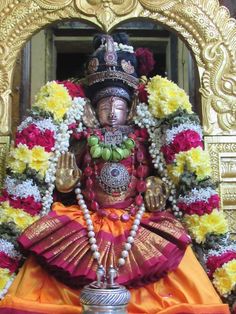 the statue is decorated with flowers and beads