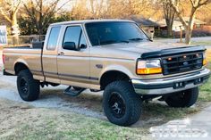 a tan ford truck parked in front of a house