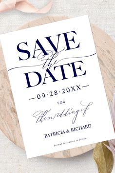 save the date cards on top of a marble plate with pink flowers and leaves next to it