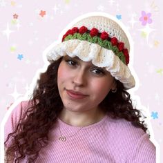 a woman wearing a crocheted hat with flowers on it's brim