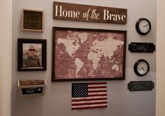 a wall with pictures, clocks and signs on it that say home of the brave