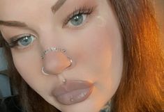 a woman with piercings on her nose and nose ring in front of her face