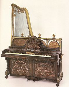 an old piano with ornate carvings on the front and sides, sitting against a white background