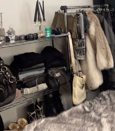 a closet filled with lots of clothes and handbags