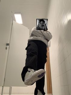 a person hanging upside down in a bathroom