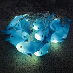 some blue lights that are on top of the ground and in the shape of fish