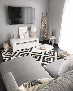 a living room filled with furniture and a flat screen tv mounted to the side of a wall