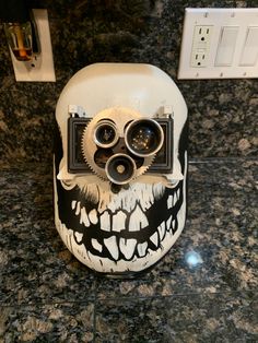 an odd looking camera on top of a white skull head with black and white designs