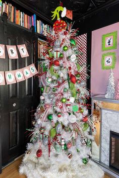 a white christmas tree with green and red ornaments