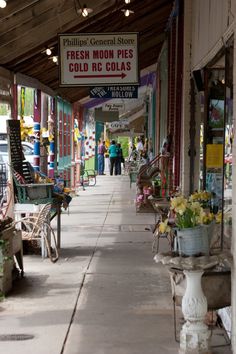 the sidewalk is lined with shops and flowers