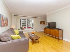 a living room filled with furniture and a flat screen tv on top of a wooden table