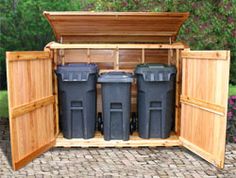 an outdoor storage shed with three trash cans in it