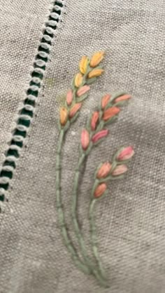 an embroidered piece of cloth with flowers on it