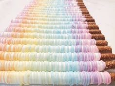 a long row of donuts with rainbow icing on them