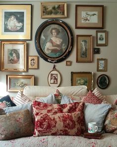 a living room filled with lots of pictures on the wall next to a couch and coffee table