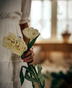 a woman holding some flowers in her hand