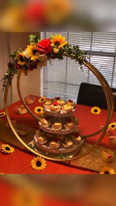 cupcakes and sunflowers are arranged in the shape of a ring on top of a table