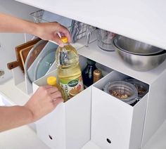 a woman is opening the drawers in her kitchen to put food into the dishwasher