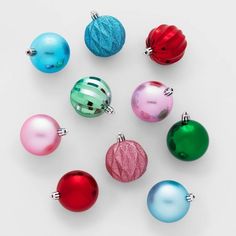 several different colored christmas ornaments on a white surface