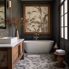 a bath room with a tub a sink and a painting on the wall above it