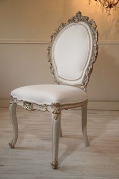 a white chair sitting in front of a chandelier